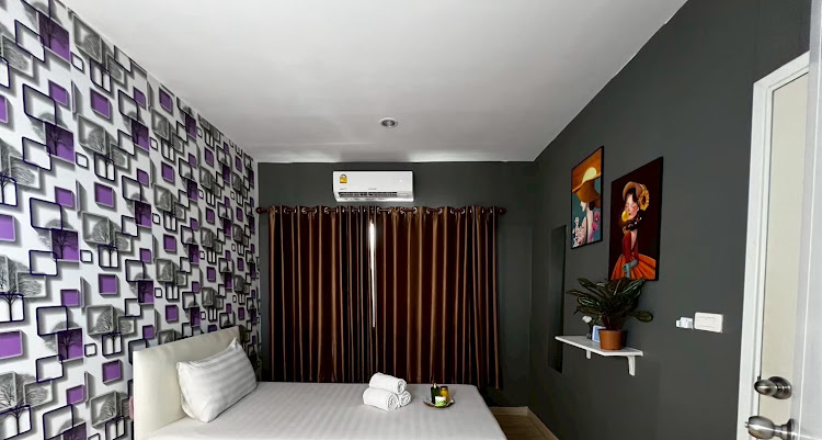 Spa room with patterned feature wall and massage bed